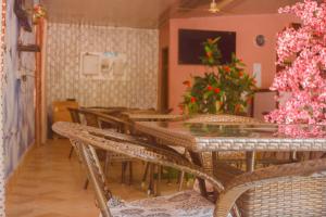 un comedor con mesa, sillas y flores en RICO HOTEL GH, en Nkawkaw