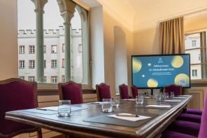 a long table in a room with a projection screen at Altstadthotel Arch in Regensburg +70 photos
