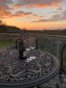 a table with a bottle of wine and a glass at Y Llofft, Llanrhidian, Gower in Swansea