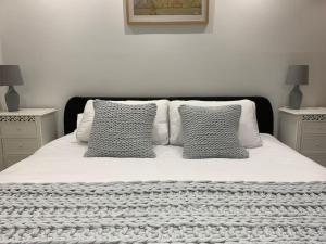 斯旺西的住宿－Y Llofft, Llanrhidian, Gower，一张白色的床,上面有三个枕头