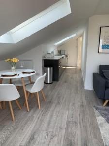 a living room with a table and chairs and a kitchen at Y Llofft, Llanrhidian, Gower in Swansea