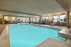 a large blue swimming pool in a hotel at Days Inn & Suites by Wyndham West Edmonton in Edmonton