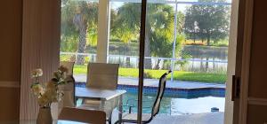 ein Esszimmer mit einem Tisch, Stühlen und einem Pool in der Unterkunft Luxury 3-Bedroom Home near Beaches with Pool in Vero Beach