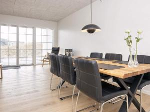 靈克賓的住宿－Apartment Ringkøbing CXXIII，用餐室配有木桌和黑椅子