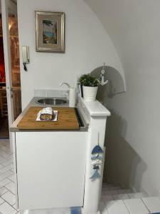 uma cozinha com um balcão com uma tábua de cortar em Nanà casa vacanza em Capri