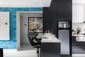 cocina con paredes de color negro y azul, mesa y sillas en Blue Haven by Sunspot Global Properties Ltd., en Abuja