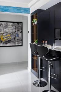 a black bar with stools in a room with a painting at Blue Haven by Sunspot Global Properties Ltd. in Abuja