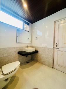 a bathroom with a toilet and a sink at The Royal View Cottage in Manāli