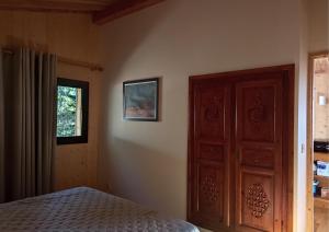 Schlafzimmer mit einem Bett und einer Holztür in der Unterkunft La Bergerie Chalet Ventoux Sud in Bédoin