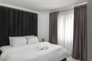 a bedroom with a large white bed and a window at Blue Haven by Sunspot Global Properties Ltd. in Abuja