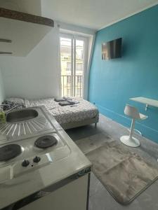 een keuken met een fornuis en een bed in een kamer bij Studio cosy - Paris 16 in Parijs