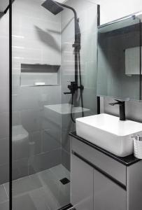 a white bathroom with a sink and a shower at Blue Haven by Sunspot Global Properties Ltd. in Abuja