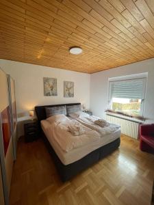 una camera con un grande letto e un soffitto in legno di Schöne helle Ferienwohnung 35606 Solms Lahn Küche separat a Braunfels