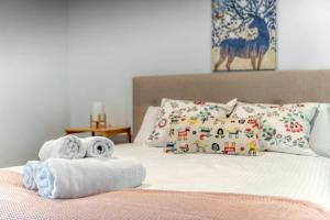 a bedroom with a bed with towels and pillows at Park Ave City delight in Canberra