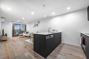 a kitchen with a counter top and a living room at Bliss In The Heart Of Canberra in Canberra