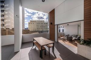 um quarto com uma mesa e vista para um edifício em Park Ave City delight em Camberra