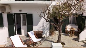 eine Terrasse mit zwei Stühlen und einem Baum in der Unterkunft Kythneria in Kythnos + 12 Fotos