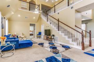 ein Wohnzimmer mit einem blauen Sofa und einer Treppe in der Unterkunft Spacious Farmersville Home with Game Room and Fire Pit in Farmersville