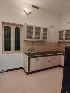 una cocina con armarios blancos y fregadero en ARUNACHALA HOUSES, en Tiruvannāmalai