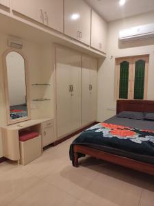 1 dormitorio con cama, tocador y espejo en ARUNACHALA HOUSES, en Tiruvannāmalai