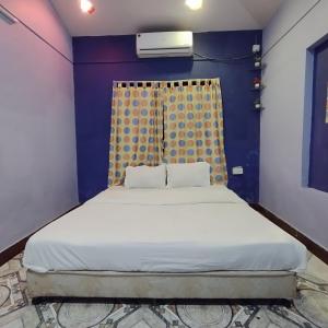 Ce lit se trouve dans un dortoir doté d'un mur bleu. dans l'établissement Blue Lagoon 2bhk, à Lonavala