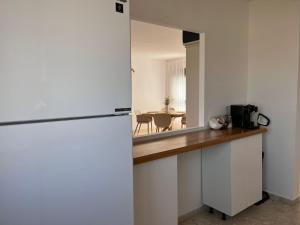 een keuken met een witte koelkast en een tafel bij Kosher for Passover Beachfront Apartment in Netanya