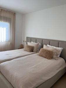 een slaapkamer met 2 bedden met witte lakens en een raam bij Kosher for Passover Beachfront Apartment in Netanya