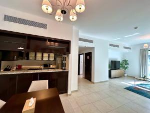 un salon avec une cuisine et une salle à manger dans l'établissement Lux BnB Travo Tower I Private Garden I Lake View, à Dubaï