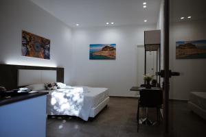 ein Schlafzimmer mit einem Bett und einem Tisch mit einem Stuhl in der Unterkunft Family House in Cefalú