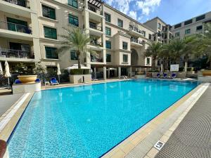 a large swimming pool in front of a building at Lux BnB Travo Tower I Private Garden I Lake View in Dubai