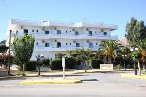 a large white building with a street in front of it at Poseidon Hotel in Amoudara Herakliou