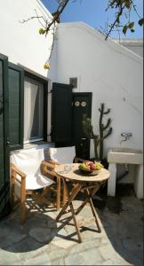 eine Terrasse mit Tisch, Stühlen und einem Waschbecken in der Unterkunft Kythneria in Kythnos