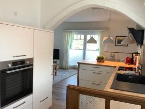 a kitchen with white cabinets and a counter top at Ferienhaus Klabautermann in Sankt Peter-Ording