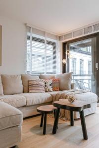 un soggiorno con un divano e un tavolo di Huswell - Pleasant 2 bedroom apartment in city center a Blankenberge