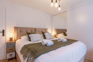 una camera da letto con un letto grande con asciugamani sopra di Huswell - Pleasant 2 bedroom apartment in city center a Blankenberge