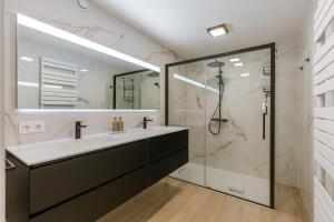 un bagno con lavandino e doccia di Huswell - Pleasant 2 bedroom apartment in city center a Blankenberge