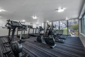 a gym with several treadmills and elliptical machines at London Circuit - City Hideaway in Canberra