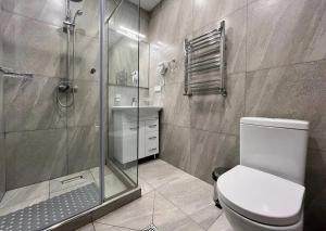 a bathroom with a shower and a toilet and a sink at Дизайнерский дом возле реки in Bjni