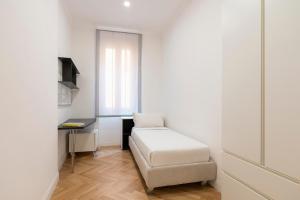 een kleine witte kamer met een bed en een bureau bij SJR Luxury Apartment Trevi Fountain in Rome