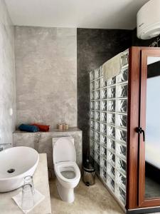 a bathroom with a toilet and a sink at Casa de Poço Guest House and Gallery in Mindelo