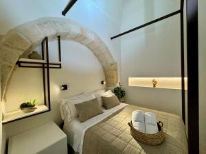 a bedroom with a bed with a stone arch at I Granai - Marea Collection in Nardò