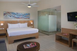 a bedroom with a bed and a glass shower at The Tropical at LHVC, Puerto Plata in San Felipe de Puerto Plata