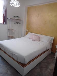 una camera con un letto bianco e un cuscino rosa di Appartamento di Giò a Palermo