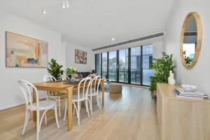 uma cozinha e sala de jantar com mesa e cadeiras em Modern Comfort Meets City Skyline em Melbourne