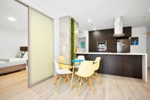 cocina y comedor con mesa y sillas en Modern 3 Bed Apartment in Melbourne CBD en Melbourne