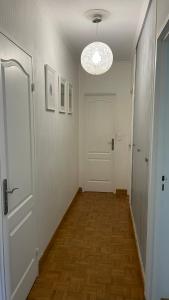 a hallway with a white door and a wooden floor at Bel Appartement lumineux à Antony. in Antony