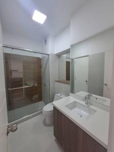 uma casa de banho com um WC, um lavatório e um espelho. em Lujoso Apartamento Ejecutivo en centro San Isidro em Lima