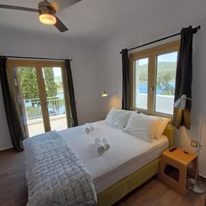 a bedroom with a large bed with a large window at Skiathos Lagoterra Apartments in Skiathos Town