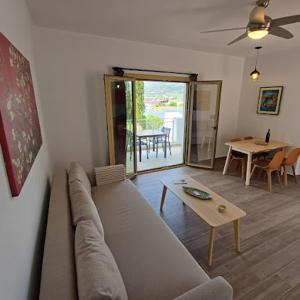 a living room with a couch and a table at Skiathos Lagoterra Apartments in Skiathos Town