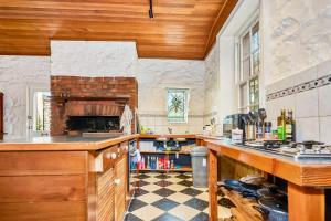 eine Küche mit Kamin und Schachbrettboden in der Unterkunft Charming Fitzroy Retreat Art, Dining, Serenity in Melbourne